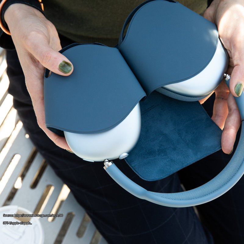 Hands holding the blue Apple AirPods Max 2 in their case. - Fair use review image from https://www.theverge.com/tech/903754/apple-airpods-max-2-review